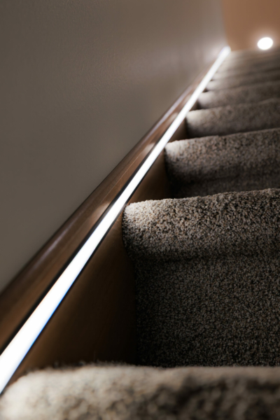 Strip lights along stair floorboards.