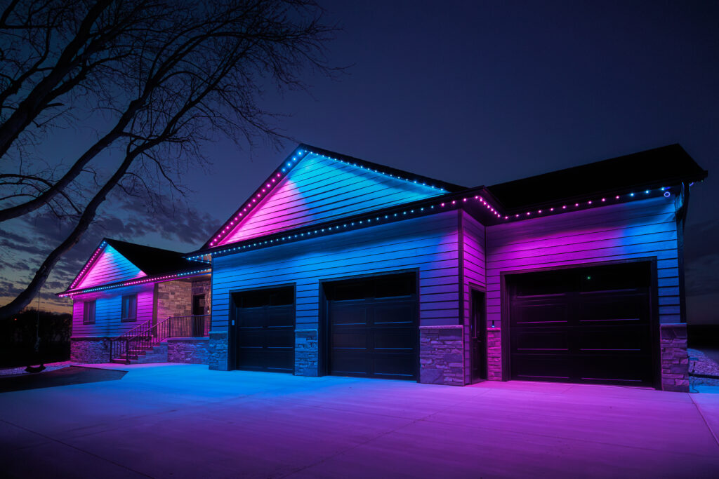 Ranch Style house lit up with pink and blue custom Gemstone Lights.